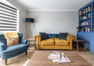 una sala de estar con sofá amarillo y estante de libros azul en Seaford Retreat with Free Parking By My Getaways, en Seaford