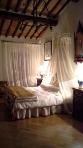Schlafzimmer mit einem Bett mit weißen Vorhängen in der Unterkunft Casa Crevole in Palazzina