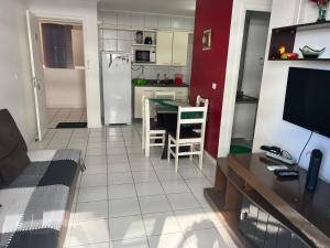 a living room with a table and a kitchen at NEO 1.0 in Maceió