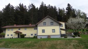 茨维泽尔FW & FH Lüsselfeld的山丘上树木背景的房子