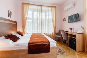 a bedroom with a bed and a desk and a window at Villa A. Malka in Poděbrady