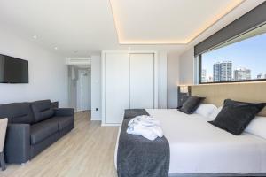een slaapkamer met een groot bed en een bank bij Hotel Cimbel in Benidorm