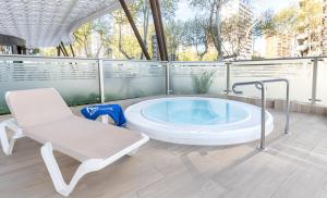 a large bath tub in a room with a chair at Hotel Cimbel in Benidorm