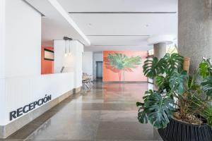 an empty lobby with plants in a building at Hotel Cimbel in Benidorm