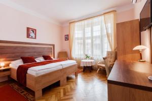 a bedroom with a bed and a desk and a window at Villa A. Malka in Poděbrady