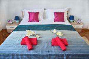łóżko z czerwonymi i białymi ręcznikami w obiekcie Apartment Marigo w mieście Banjole