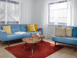 a living room with a blue couch and two tables at Zwick Apartments in Kammerstein