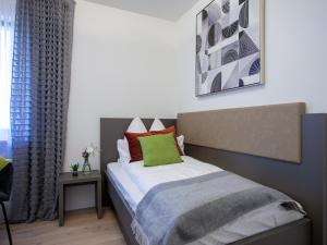 a bedroom with a bed with a green pillow at Zwick Apartments in Kammerstein