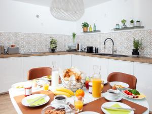 a table with breakfast foods and orange juice in a kitchen at Zwick Apartments in Kammerstein