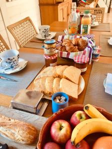 stół z chlebem, jabłkami i innym jedzeniem w obiekcie Chambre, spa, petit déjeuner w mieście Le Buet