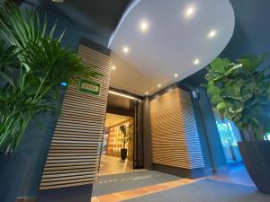 a hallway with potted plants in front of a building at Alevic Hotel Sirmione in Sirmione