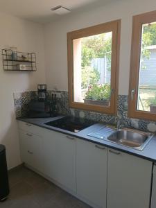 een keuken met een wastafel en een raam bij Gite Pak'Home maison à la campagne 3 étoiles avec wifi in Lombray