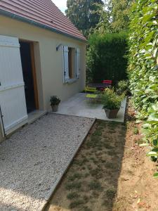 eine Terrasse mit einem Tisch und Stühlen vor einem Haus in der Unterkunft Gite Pak'Home maison à la campagne 3 étoiles avec wifi in Lombray