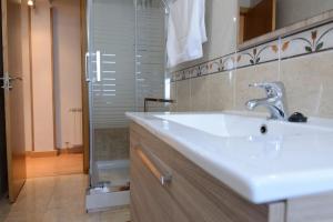 a bathroom with a white sink and a shower at DOMUS SALAMANCA EDISSON in Salamanca