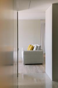 un divano bianco in soggiorno con banane di The Editory By The Sea Troia Comporta Hotel a Tróia
