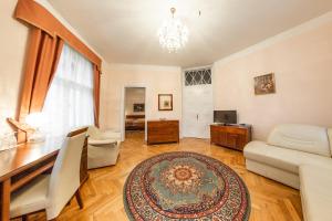 uma sala de estar com uma secretária, um sofá e uma televisão em Villa A. Malka em Poděbrady