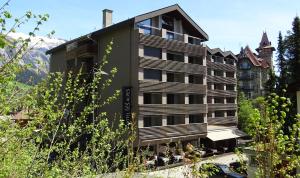 a hotel with a building in the mountains at Studio im Hotel Des Alpes in Flims