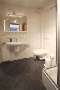 ein Badezimmer mit einem Waschbecken, einem WC und einem Spiegel in der Unterkunft Yachthafenresidenz - Wohnung 9203 / 894 in Kühlungsborn