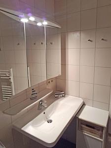 a white bathroom with a sink and a mirror at Yachthafenresidenz-Wohnung-9307-899 in Kühlungsborn