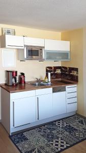 a kitchen with white cabinets and a sink at Yachthafenresidenz-Wohnung-9307-899 in Kühlungsborn