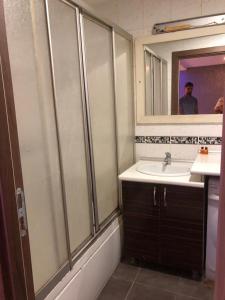 un bagno con lavandino e un uomo nello specchio di FATIH - TUYAP APART'S a Kırac
