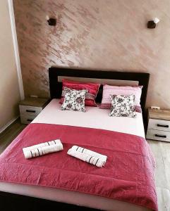 a bedroom with a red and white bed with two pillows at Studio Elena in Tivat