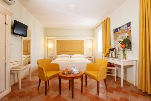 a hotel room with a bed and two chairs and a table at Antica Fornace Relais by La Principina in Principina Terra