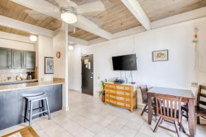 eine Küche und ein Esszimmer mit einem Tisch und einem TV in der Unterkunft Kona Bali Kai #374 in Kailua-Kona