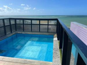 uma piscina numa varanda com vista para o oceano em NEO 1.0 em Maceió