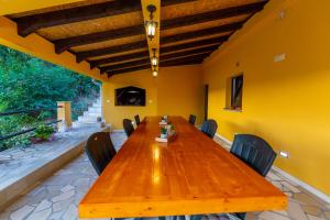 a dining room with a wooden table and chairs at HOLIDAY HOME IVA, Proložac - Makarska in Donji Proložac