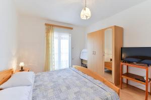 a bedroom with a large bed and a television at Apartment Tkon 336b in Tkon