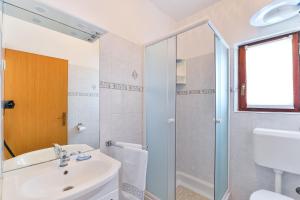 a white bathroom with a sink and a shower at Apartment Tkon 336b in Tkon