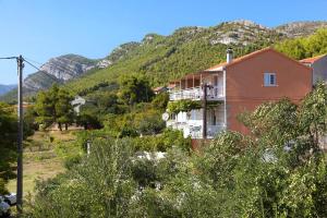 a house on a hill with mountains in the background at Apartments with a parking space Zuljana, Peljesac - 254 in Žuljana