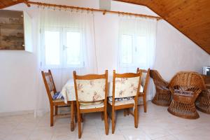 a dining room with chairs and a table and windows at Apartments with a parking space Zuljana, Peljesac - 252 in Žuljana