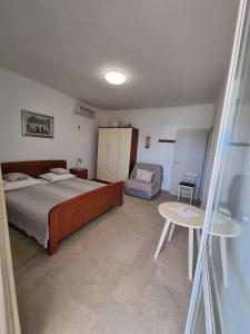 Un dormitorio con una cama y una mesa. en Family friendly seaside apartments Nevidjane, Pasman - 325, en Neviđane