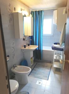 a bathroom with a toilet and a sink and a tub at Apartment Kornic 416b in Kornić