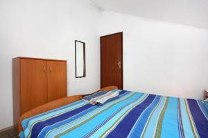 a bedroom with a bed with a blue striped blanket at Apartment Biograd na Moru 368b in Biograd na Moru