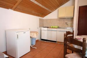 a small kitchen with a white refrigerator and a table at Apartment Biograd na Moru 368b in Biograd na Moru
