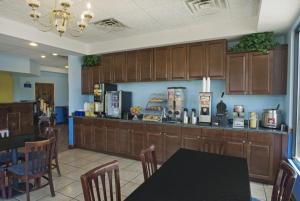 a kitchen with a counter and a table and chairs at Days Inn by Wyndham Richmond Hill/Savannah in Richmond Hill