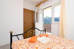 ein Schlafzimmer mit einem Bett mit orangefarbenen Handtüchern darauf in der Unterkunft Apartments and rooms by the sea Zuljana, Peljesac - 256 in Žuljana