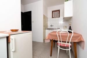 a small kitchen with a table and a chair at Apartments and rooms by the sea Zuljana, Peljesac - 256 in Žuljana