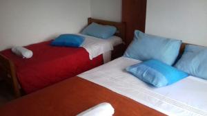 two beds with blue pillows in a room at Secluded fisherman's cottage Krknata, Dugi otok - 399 in Žman