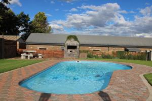 a large swimming pool in front of a barn at d Olive Rose Boutique Hotel Danielskuil in Daniëlskuil