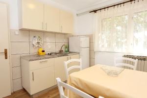 a kitchen with a table and a white refrigerator at Apartments and rooms by the sea Trpanj, Peljesac - 258 in Trpanj