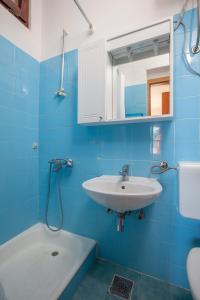 a blue bathroom with a sink and a mirror at Apartment Igrane 310e in Igrane +16 photos