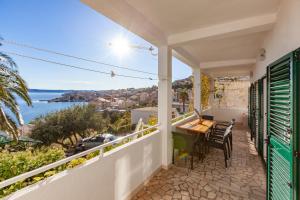 a balcony with a table and chairs and a view of the water at Apartment Igrane 310e in Igrane