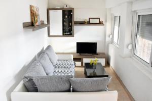 a living room with a white couch and a tv at Secluded fisherman's cottage Cove Zuborovica, Pasman - 322 in Mrljane