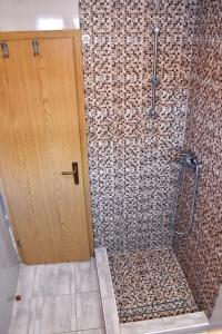 a shower with a wooden door in a bathroom at Secluded fisherman's cottage Cove Zuborovica, Pasman - 322 in Mrljane
