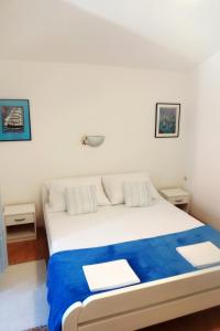 een slaapkamer met een groot wit bed met blauwe lakens bij Apartments with a parking space Podaca, Makarska - 312 in Podaca