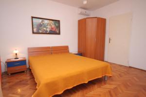 a bedroom with a bed with a yellow blanket on it at Rooms by the sea Pag - 278 in Pag
